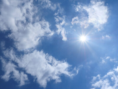 Frühlingshimmel mit Wolken und heller Sonne
